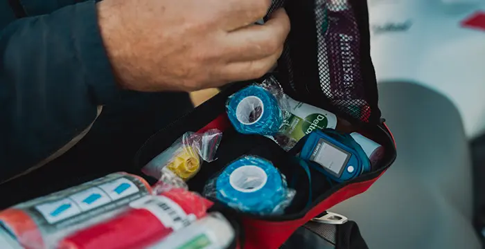 First aid kit placed on an adventure bike on a gravel road during a guided tour.