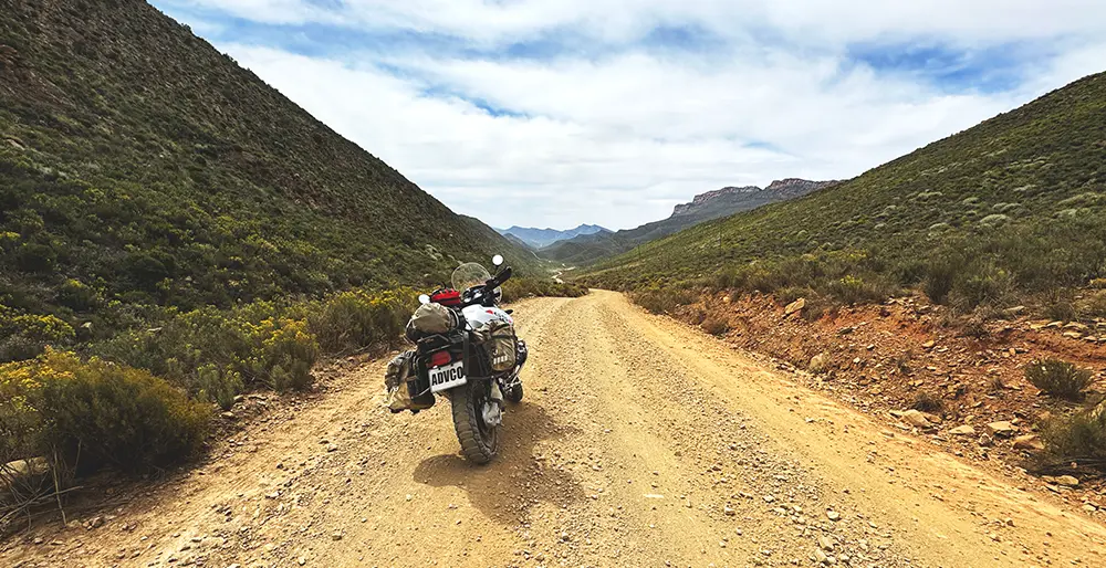 An adventure bike in between mountains leading into the Karoo
